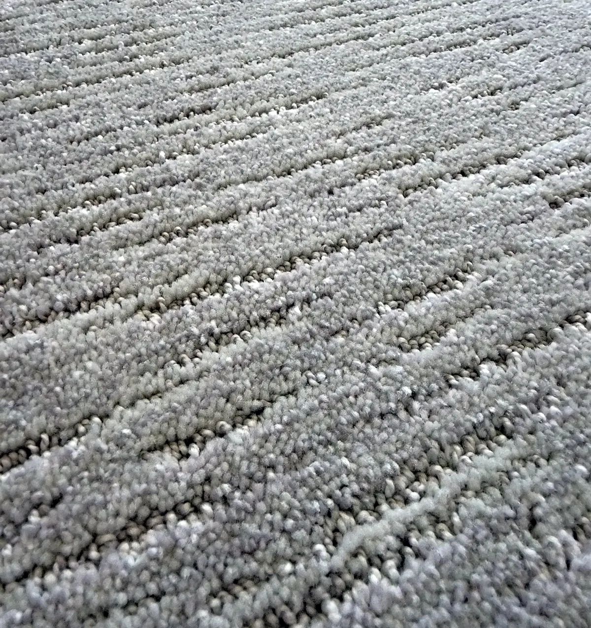 Level cut loop carpet with a linear textured pattern